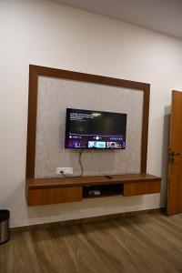 a flat screen tv sitting on a wall at Nicolas Farm & Resort in Mansar