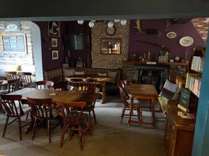 a dining room with tables and chairs and a fireplace at The Cross Keys in Worthington