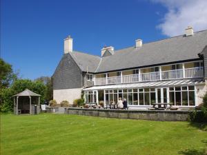 a large house with a large lawn in front of it at Renvyle House Hotel & Resort in Renvyle