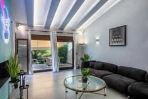 a living room with a couch and a glass table at NeonChic Jacuzzi and Pool Villa in Sani Beach