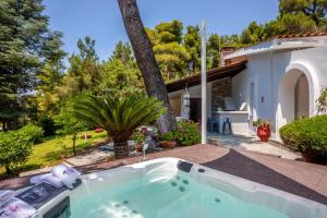 a hot tub in the backyard of a house at NeonChic Jacuzzi and Pool Villa in Sani Beach