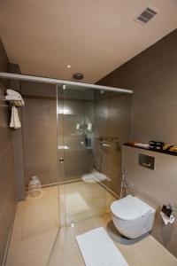 a bathroom with a glass shower with a toilet at Hotel Noble Residency in Kizhillam +6 photos