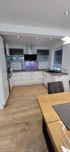 a kitchen with white cabinets and a wooden table at Ferienwohnung in Lohrheim in Lohrheim
