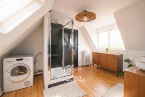 a bathroom with a washing machine and a sink at Havre de paix avec jacuzzi - Hyper-centre du Mans in Le Mans