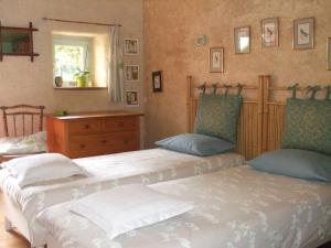 une chambre avec deux lits et une commode dans l'établissement La Sirène Endormie, à Penmarcʼh