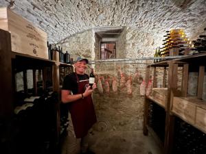 a man holding a bottle of wine in a wine cellar at Podere Vecci in Dicomano +72 photos