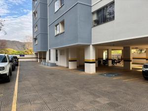 a large building with cars parked in a parking lot at Flat Di Roma 110A Rio Quente in Rio Quente