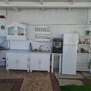 a kitchen with white cabinets and a white refrigerator at Casa Dorin in Orşova