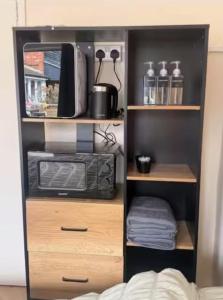 a book shelf with a microwave oven and a microwave at The Burrow at Black Rabbit Pub in Haybridge