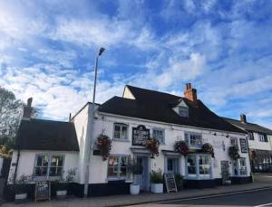 a white building on the corner of a street at The Burrow at Black Rabbit Pub in Haybridge