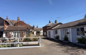 a row of houses in a town with a white fence at The Burrow at Black Rabbit Pub in Haybridge