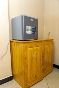 a microwave sitting on top of a wooden cabinet at La casa Cottage in Iringa