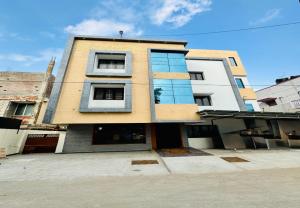 a tall building with glass windows on a street at Nandha Grande Elite in Udumalaippettai