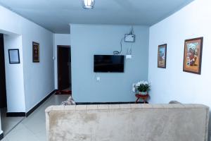 a living room with a couch and a blue wall at La casa Cottage in Iringa +7 photos