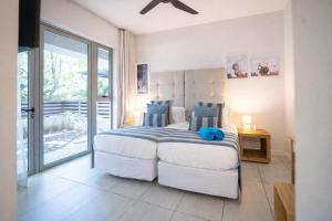 a bedroom with a large bed with blue pillows at Manta Cove by Blue Zebra Holidays in Rivière Noire +22 photos
