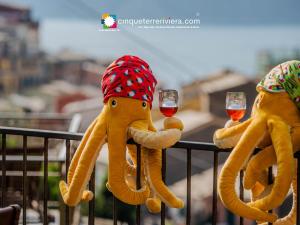 two stuffed elephants holding wine glasses on a railing at Camere Giuliano basso in Vernazza