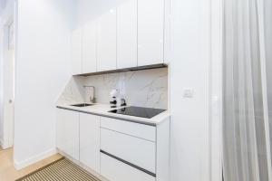 a kitchen with white cabinets and a sink at YBH Mare Boutique in Vigo