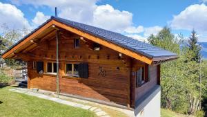 a log cabin with a solar roof at Chalet AS des Pics in Nendaz