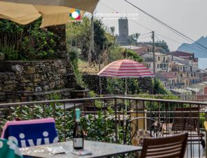 a table and chairs and an umbrella on a balcony at Camere Giuliano basso in Vernazza