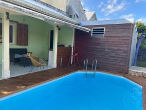 a swimming pool in front of a house at Le cocon de Coco in Lamentin