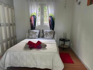a bedroom with a white bed with flowers on it at Le cocon de Coco in Lamentin
