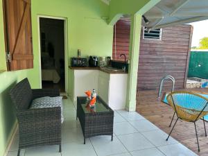 a patio with a table and chairs and a kitchen at Le cocon de Coco in Lamentin