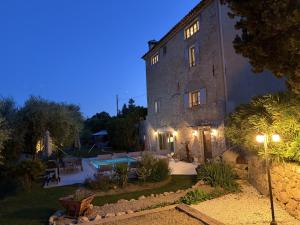 a large stone building with a courtyard at night at Bastide de Peyloubet in Grasse
