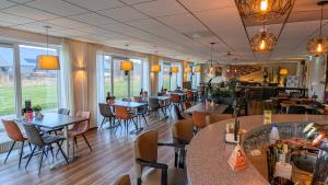 a restaurant with tables and chairs and a bar at Hotel B&B d'Olde Smidse in Giethoorn