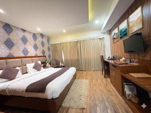 a bedroom with a bed and a desk and a television at Hotel Royal Serena in Ambāla