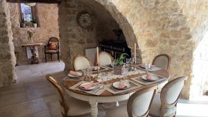 a dining room with a table with chairs and a fireplace at Bastide de Peyloubet in Grasse