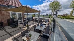 a patio with tables and chairs and an umbrella at Hotel B&B d'Olde Smidse in Giethoorn
