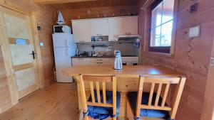 a kitchen with a wooden table and a refrigerator at Hausboat Kvapka in Jarovce