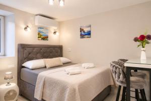 a bedroom with two beds and a table and a desk at Casa del Sole - Ugljan Island in Poljana