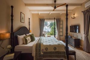 a bedroom with a large bed and a window at SaffronStays RiverSong Britona in Ribandar +40 photos