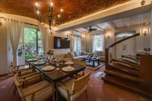 a dining room and living room with a table and chairs at SaffronStays RiverSong Britona in Ribandar