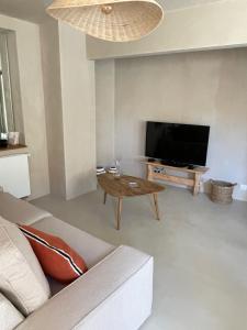 a living room with a couch and a flat screen tv at Maison Maragelie in Westhoffen