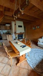 ein Wohnzimmer mit einem Holztisch und Stühlen in der Unterkunft Przytulicha in Bystre