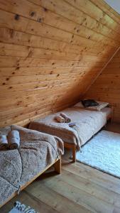 zwei Betten in einem Zimmer mit Holzdecke in der Unterkunft Przytulicha in Bystre