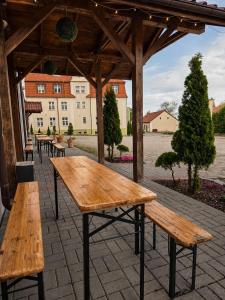 a wooden table and benches on a patio at Młyn Warmiński -Hotelik Hermes in Pieniężno