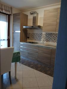a kitchen with wooden cabinets and a table and a stove at Spazioso appartamento su due piani in Leinì