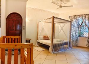 a bedroom with a bed with a canopy at Penety Villa in Shanzu