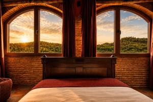 a bedroom with a bed and two windows with a view at Fortaleza Medieval La Manyosa in Granera +66 photos