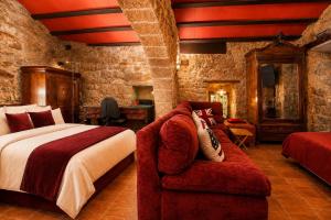 a bedroom with a large bed and a couch at Fortaleza Medieval La Manyosa in Granera