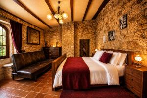 a bedroom with a bed and a leather couch at Fortaleza Medieval La Manyosa in Granera