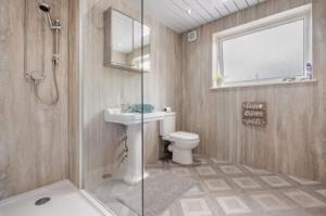 a bathroom with a toilet and a sink and a shower at The Waterside Apartment 6 in Largs