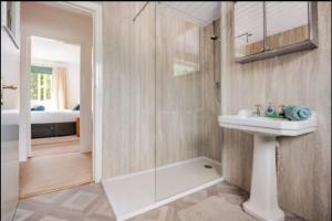 a bathroom with a sink and a shower and a mirror at The Waterside Apartment 6 in Largs