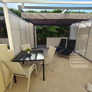 a patio with a table and chairs and a canopy at Bungalow Gran Canaria Oasis in Maspalomas