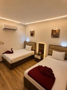 a hotel room with two beds and a red blanket at Anubis Pyramids View Inn in Cairo