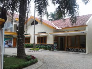 ein Gebäude mit einer Palme davor in der Unterkunft Morse Guest house in Malang