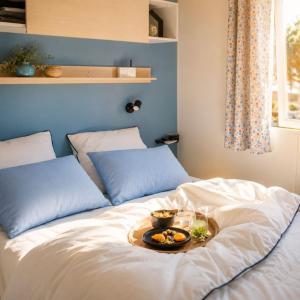a bed with a tray of food on it at Camping Amélia in Amélie-les-Bains-Palalda